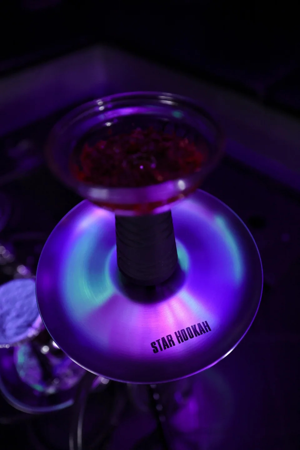 Colored light reflecting across a hookah tray