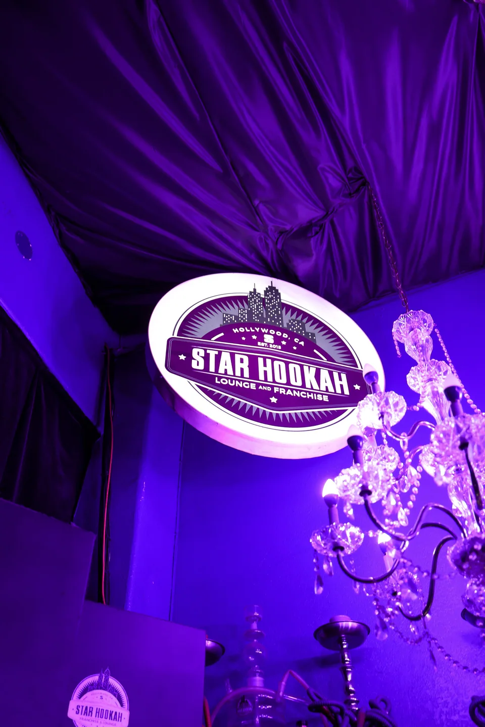 Star’s illuminated circular sign beside a chandelier