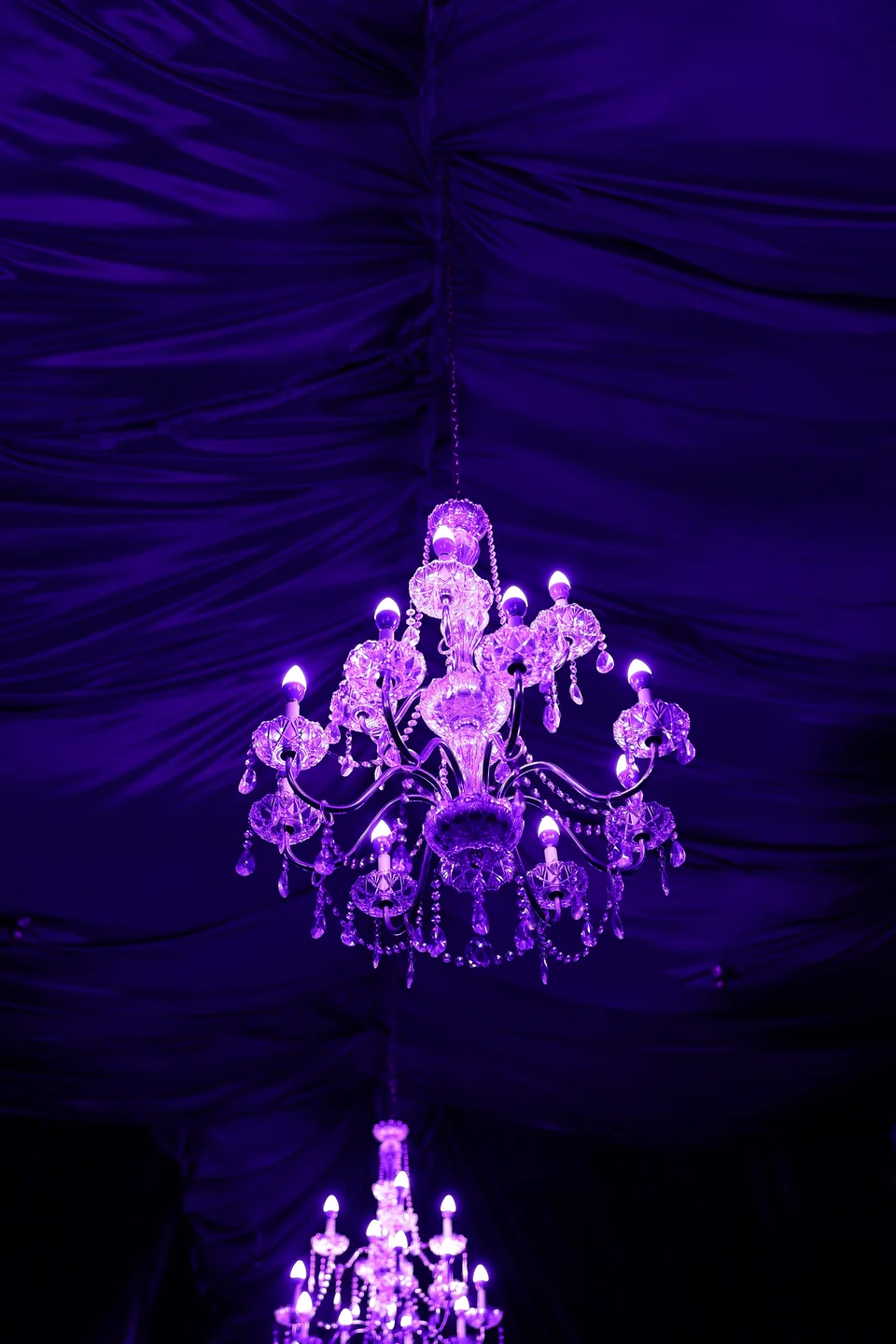 A crystal chandelier against the draped ceiling