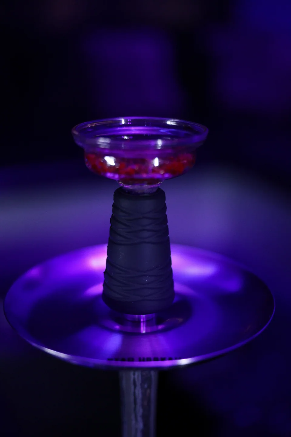 A hookah bowl and stem in violet light