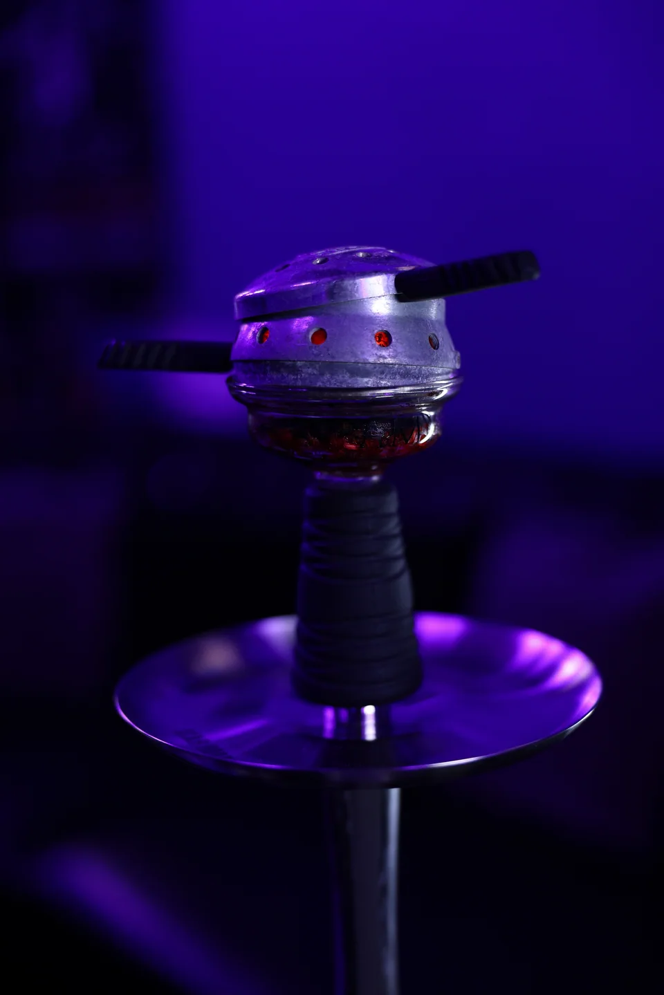 A metal hookah bowl above its dark stem