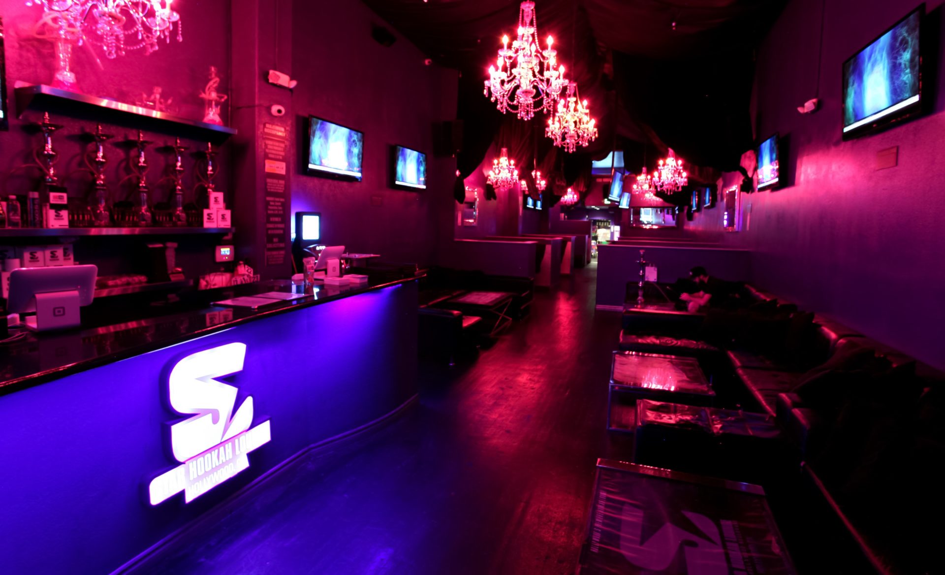 Star’s Hollywood lounge with glowing purple lighting and crystal chandeliers